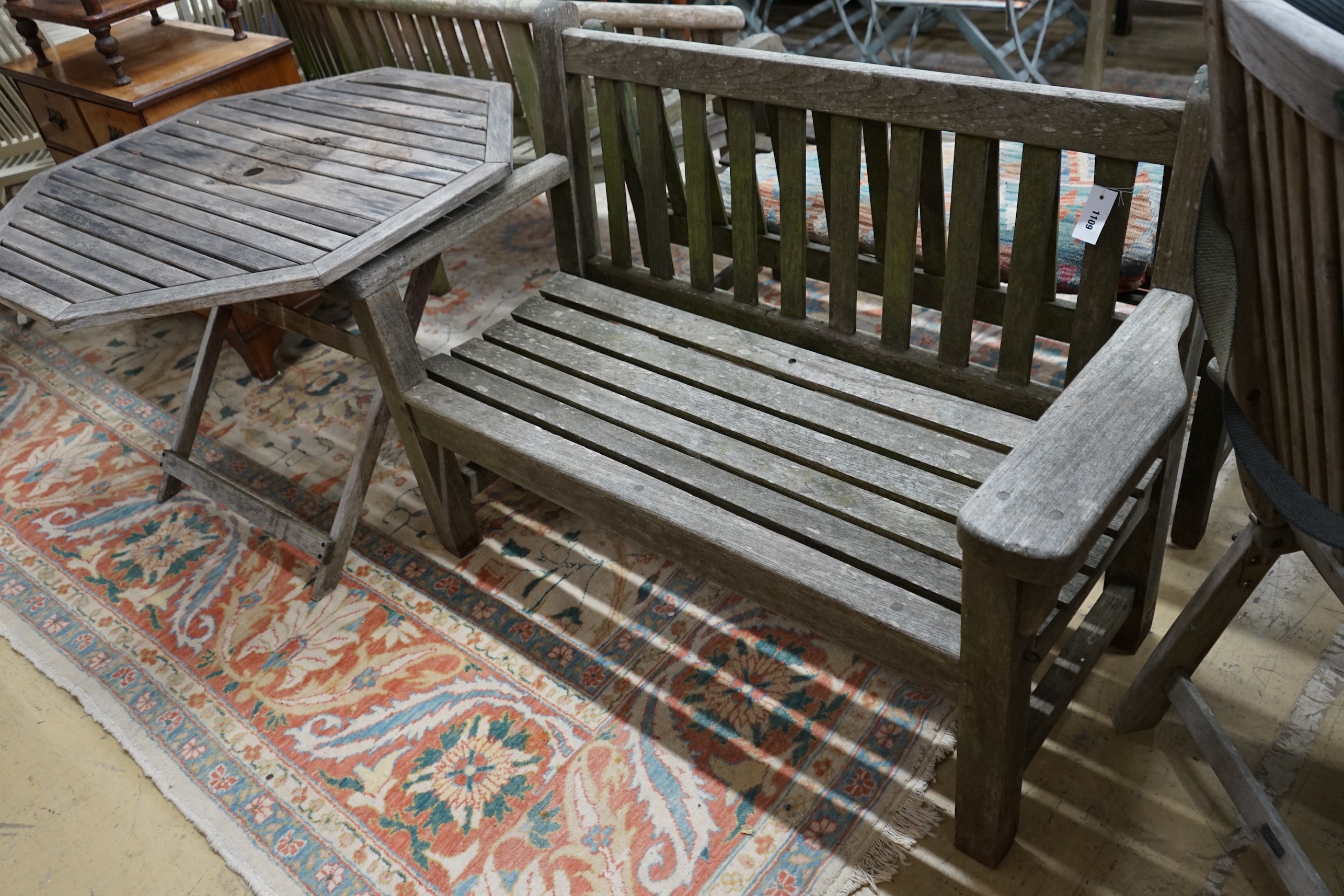 A weathered teak garden bench and an octagonal garden table, width 100cm, height 69cm